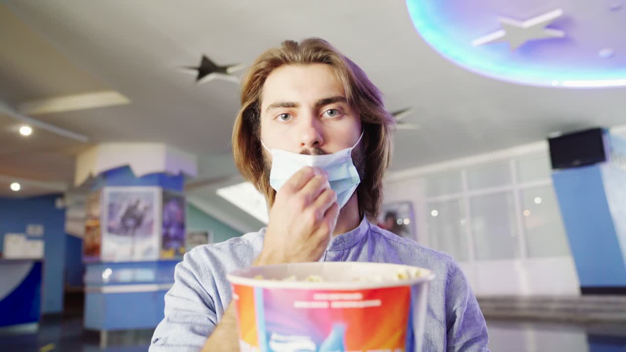 hombre comiendo palomitas de maíz en un cine