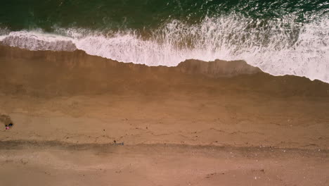 Drohnenvogelperspektive-Von-Wellen,-Die-Auf-Einem-Strand-Landen-Und-Seitwärts-Von-Rechts-Nach-Links-Verlaufen