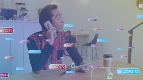 Animación-De-Barras-De-Notificación,-íconos,-Hombre-Asiático-Mirando-Una-Tableta-Digital-Y-Hablando-Por-Teléfono-Celular