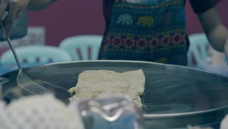 skilled man with watch on left hand adds butter on pastry