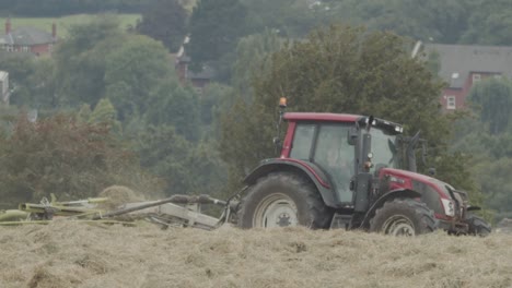un tractor se mueve a través de un campo cosechando una cosecha