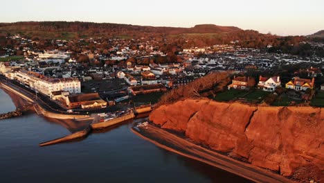 aerial view of sidmouth town beside coastline bathed in golden sunrise light