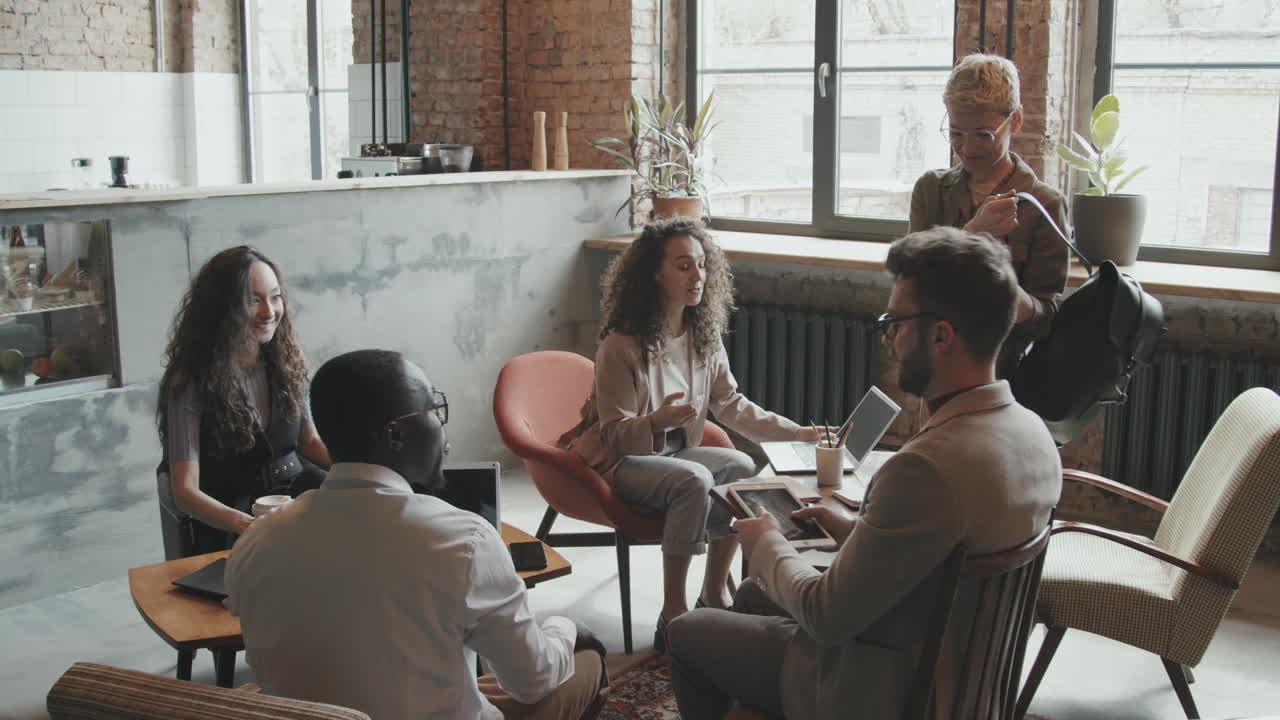 Business Partners Arriving at Informal Meeting in Loft Coworking Space