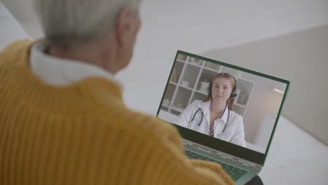 young female therapist is answering on questions of old person online, elderly man is listening and viewing her on display, telehealth