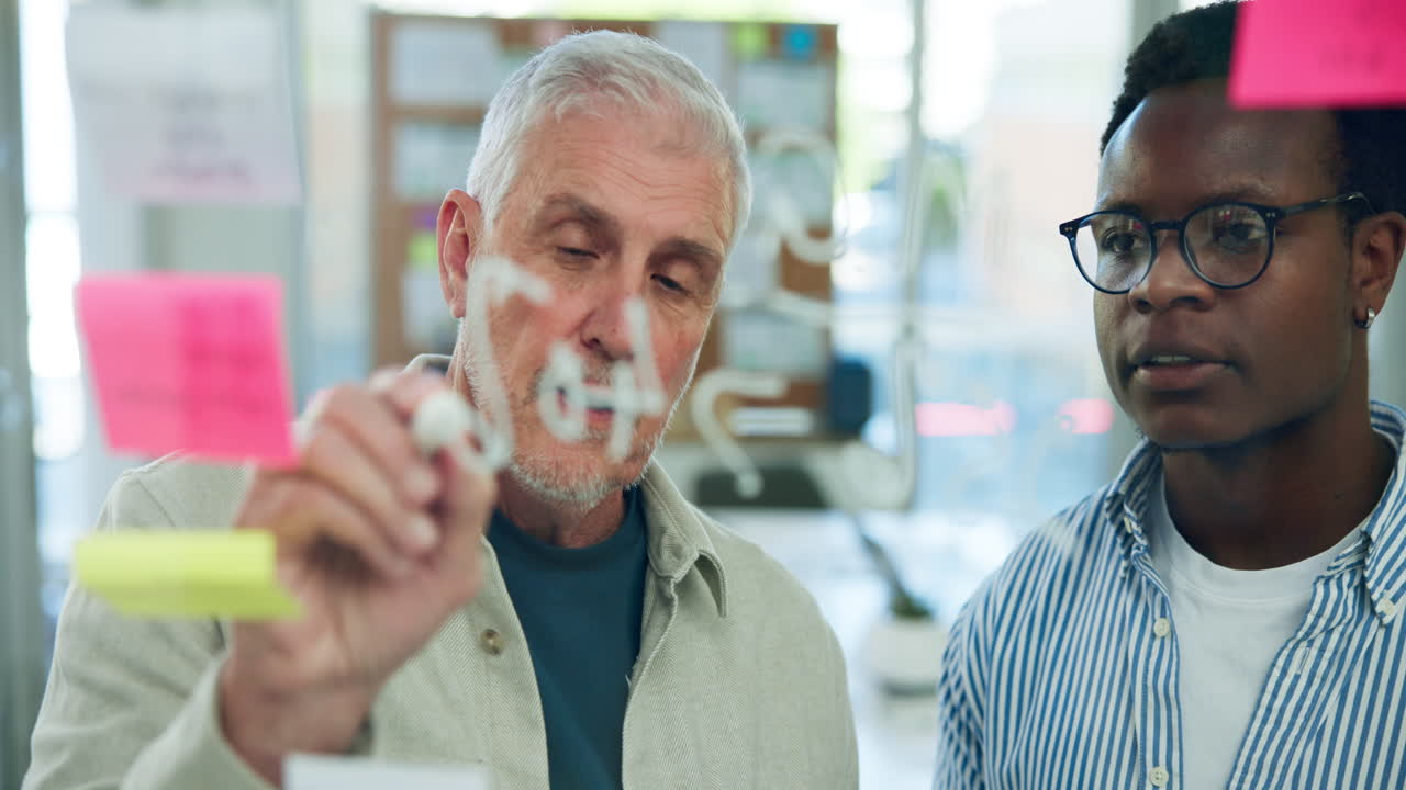 Diverse Businessmen Brainstorming and Writing on a Glass Board