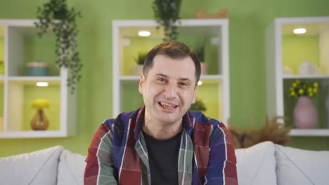 happy man pretending to chat while laughing at camera.