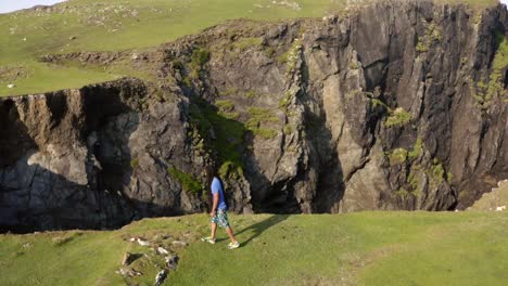 Man-with-long-dreads-contemplating-a-cliff