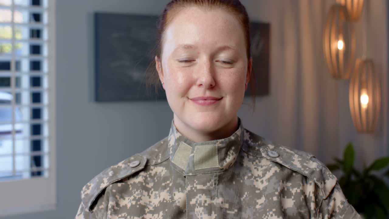 Smiling woman in military uniform, looking at camera in indoor setting