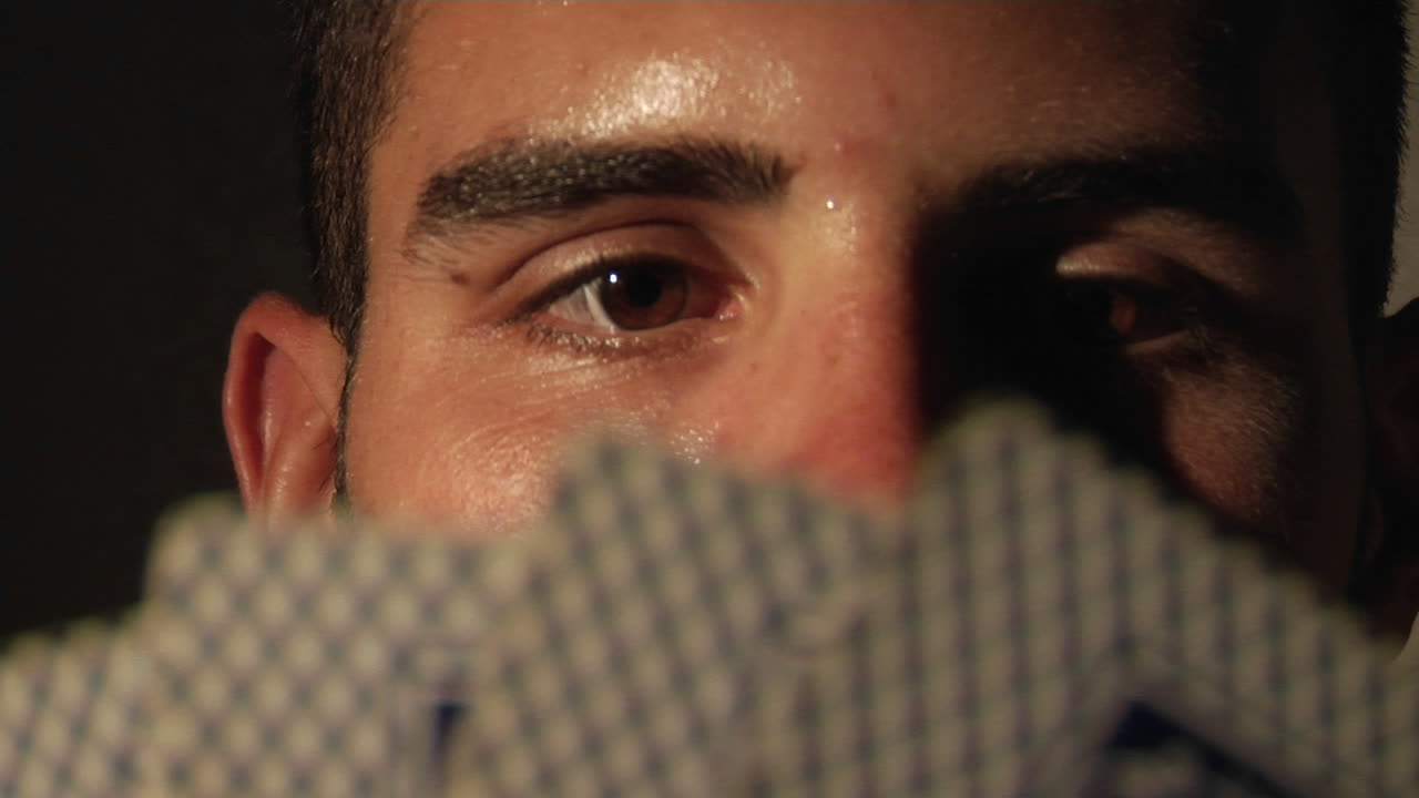 un hombre estudia sus cartas y luego mira a su derecha mientras contempla su próximo movimiento