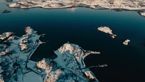 skarungen campsite with snowscape mountain ridge in kabelvag, norway. aerial tilt-up shot