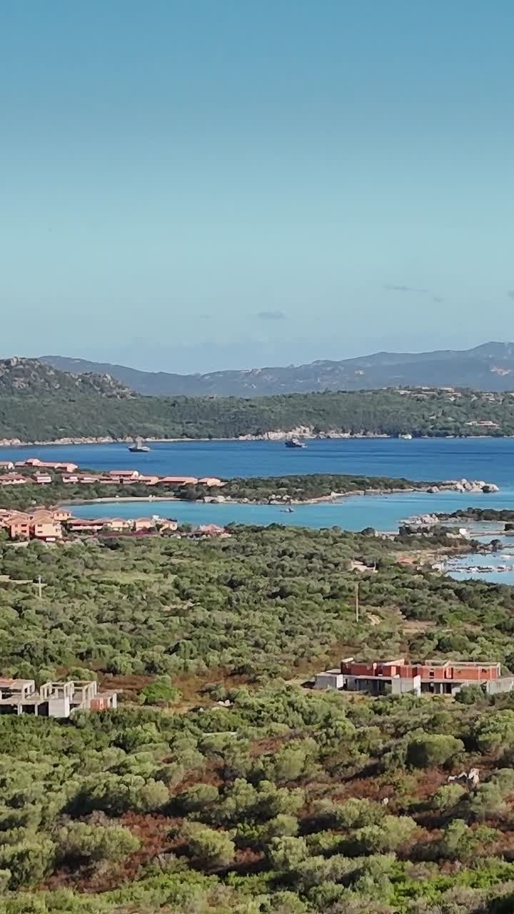 Sardinya kıyısının, tekneler ve uzaktaki dağlarla birlikte güzel manzarası