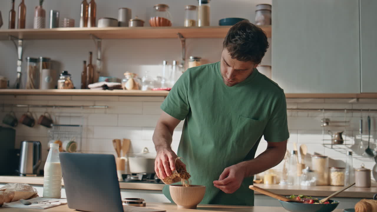 Cooking guy looking laptop preparing breakfast in kitchen closeup. Man cooking