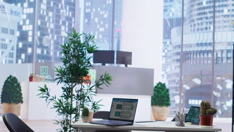 laptop on desk in office showing stock exchange indices