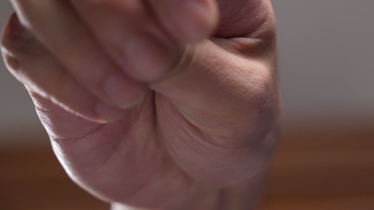 Close-up of a hand sprinkling peppercorns. Slow motion