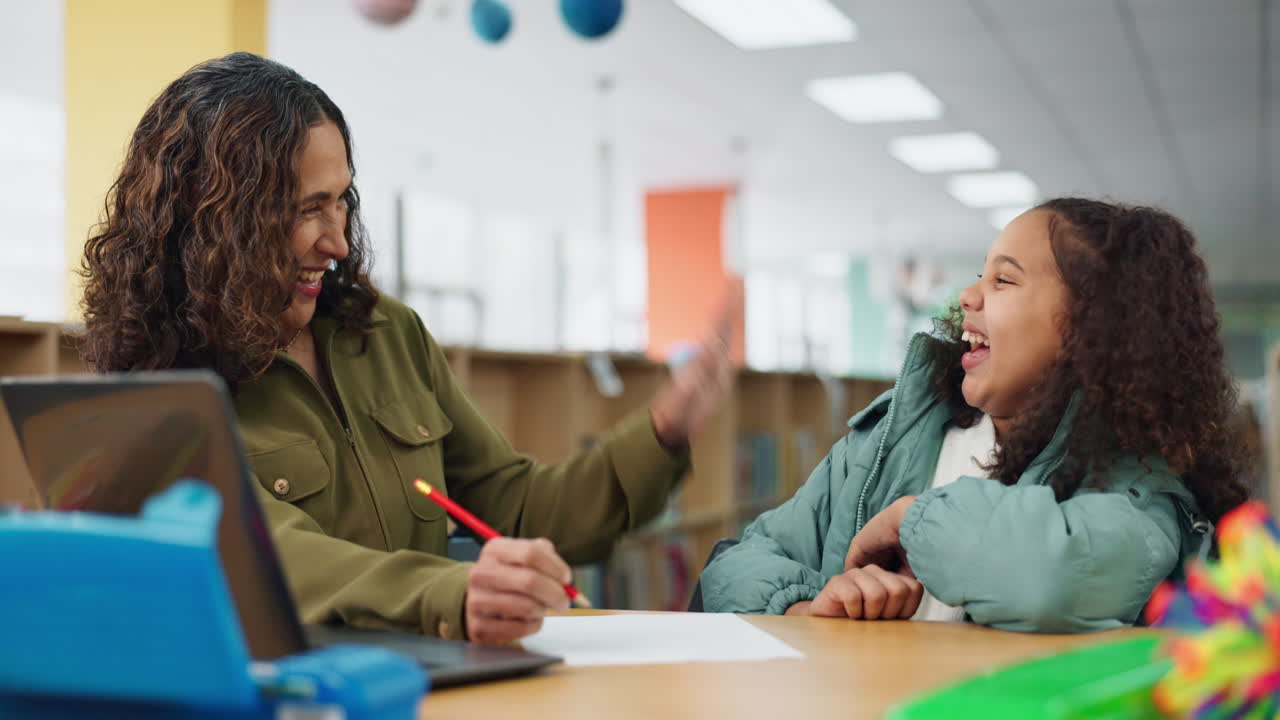 Teacher and Student High Five in Library