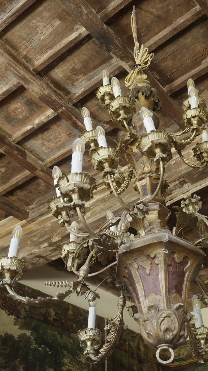 Ornate Golden Chandelier Hanging from a Wooden Ceiling
