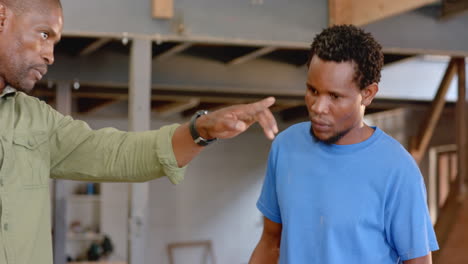 pointing african american men guiding construction in woodshop, with pencil and columns, copy space