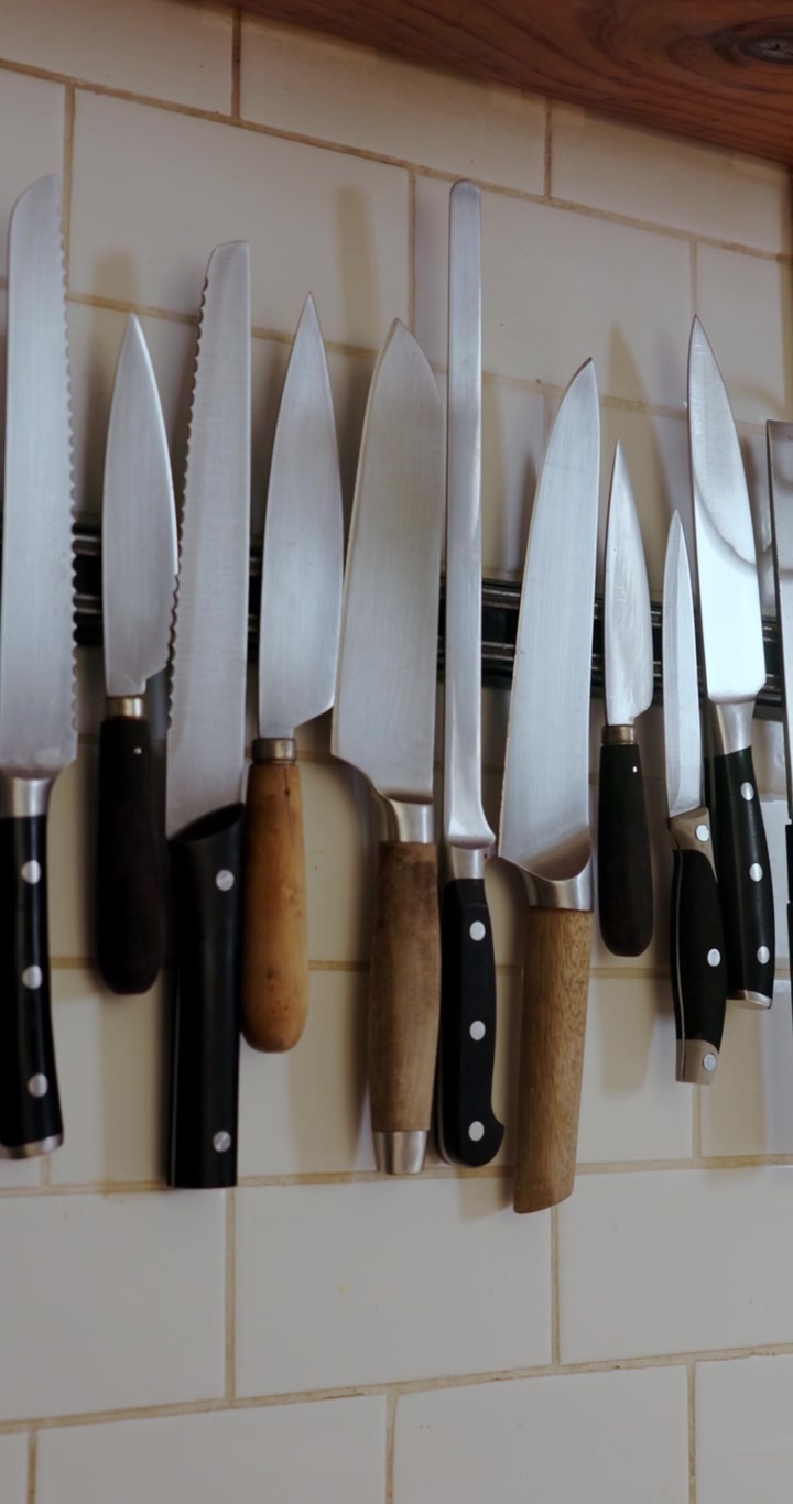 Assorted Kitchen Knives Hanging on Magnetic Wall Strip