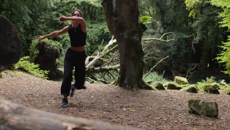 Low-Angle-Aufnahme-Einer-Jungen-Latina,-Die-Ihre-Capoeira-Bewegungen-Im-Barna-Wald-Verbessert