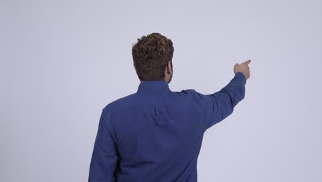 손가락을 가리키는 젊은 수염을 가진 인도 사업가의 뒷면