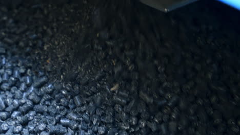 shiny pieces of black charcoal falling down from the pipe. pressed charcoal uploaded for heating the grain storage. close up for charcoal background.
