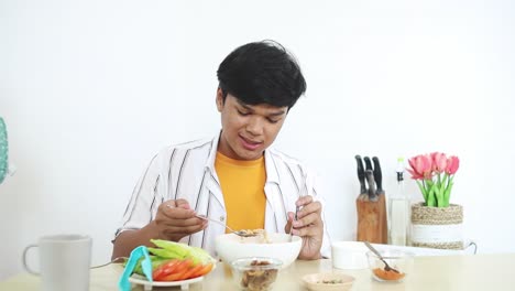 man enjoying noodles at home