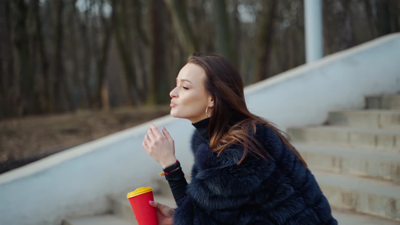 Fashion girl outdoor portrait. Beautiful girl posing on the street with coffee in hands