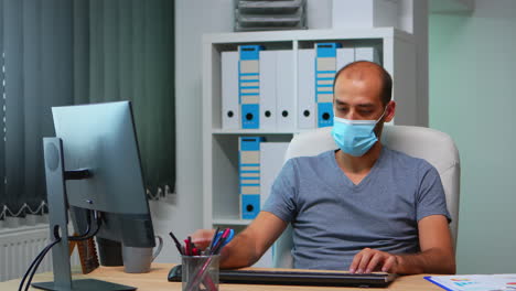 con máscara facial gerente trabajando en la oficina
