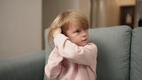 Little-funny-girl-trying-to-wear-ear-plugs-taking-out-her-earphones