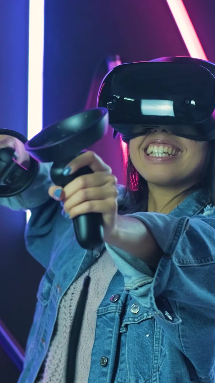 Giovane donna che gioca a un gioco di realtà virtuale in una stanza illuminata al neon