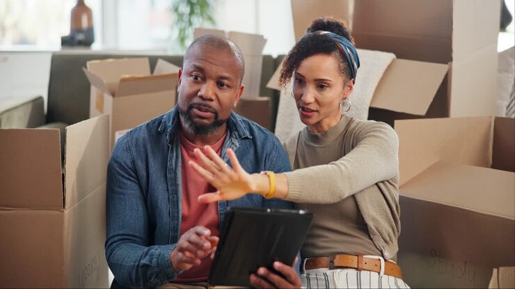 Couple looking at a tablet during a move
