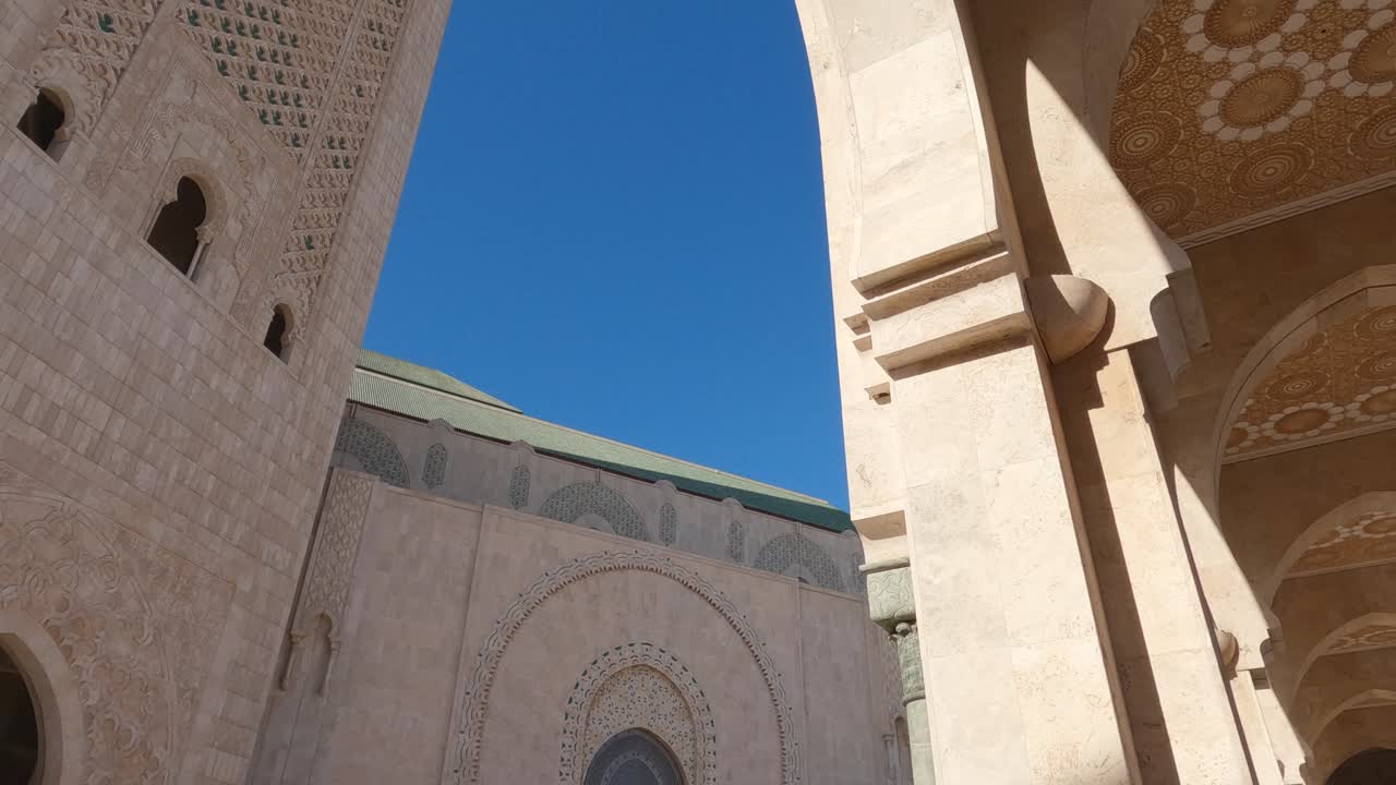Astounding minaret of Hassan Mosque in low angle tilt down view