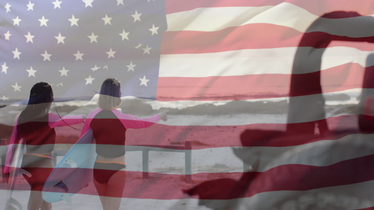 Animation of flag of usa over happy diverse women with surfboards on beach in summer