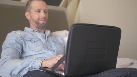 un hombre caucásico de mediana edad está trabajando en su computadora portátil que está dentro de una funda protectora negra