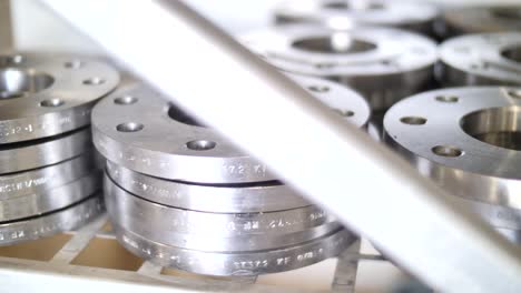 shiny new stainless steel flanges piled on warehouse, market shelf, close up