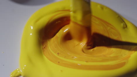 mixing yellow paint on a palette