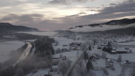 Gefrorenes-Winterdorf-Mit-Tiefen-Wolken-Und-Einem-Fluss