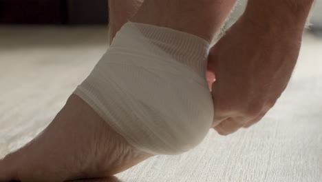 ankle wrapped in bandages and bandage being tied up