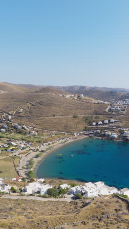 episkopi beach with merichas village and port in background on kythnos island, cyclades, aerial, vertical
