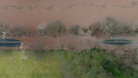 fotografía aérea de arriba hacia abajo de una calle inundada de barro en un área suburbana con agua de río sucia después de fuertes lluvias en estados unidos