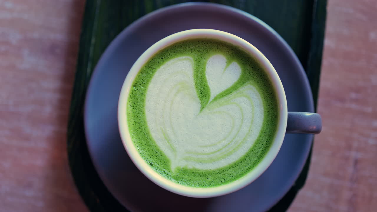 Close up of a matcha latte on a little green tray at a cafe