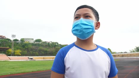 asian boy wearing the medical flu mask at stadium