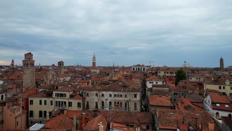 Aerial-rising-in-small-square-of-San-Polo-district-revealing-Venice-city,-Italy