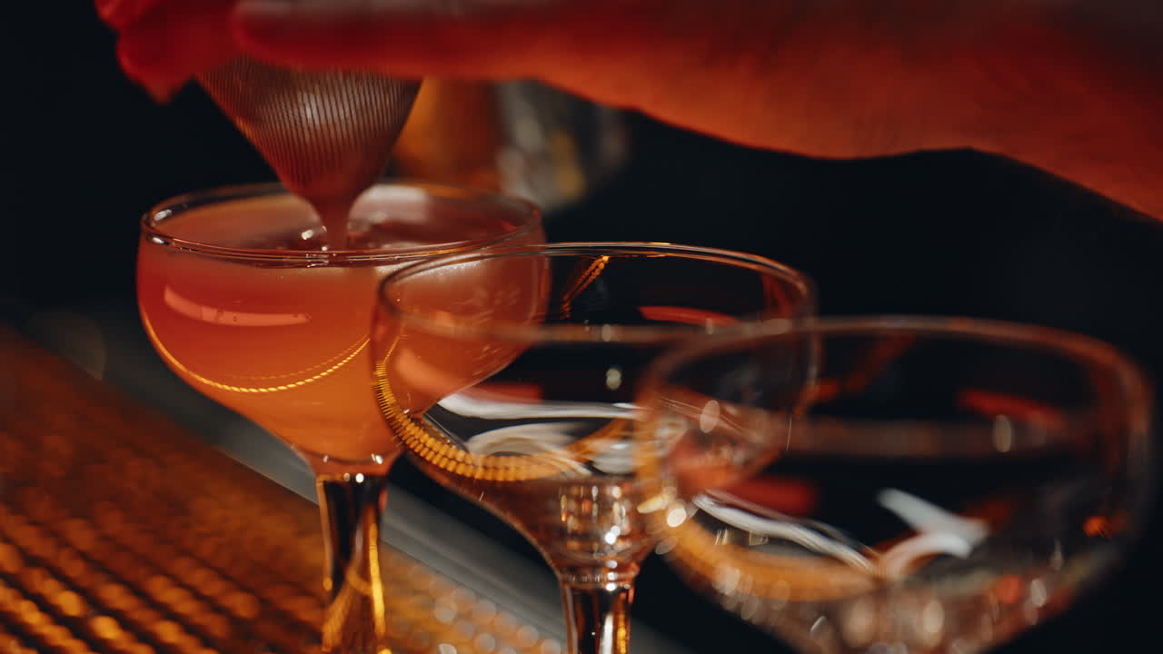 Il barista versa un ingrediente filtrato per cocktail in un barman di un night club, primo piano
