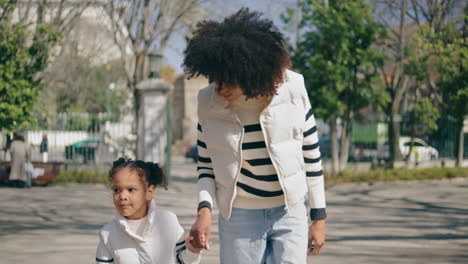 mother daughter walking city at sunny holiday. family leisure.