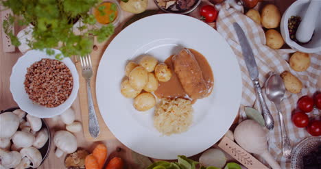 Mahlzeit-Im-Teller-Inmitten-Verschiedener-Zutaten-Auf-Holztisch-Sortiert