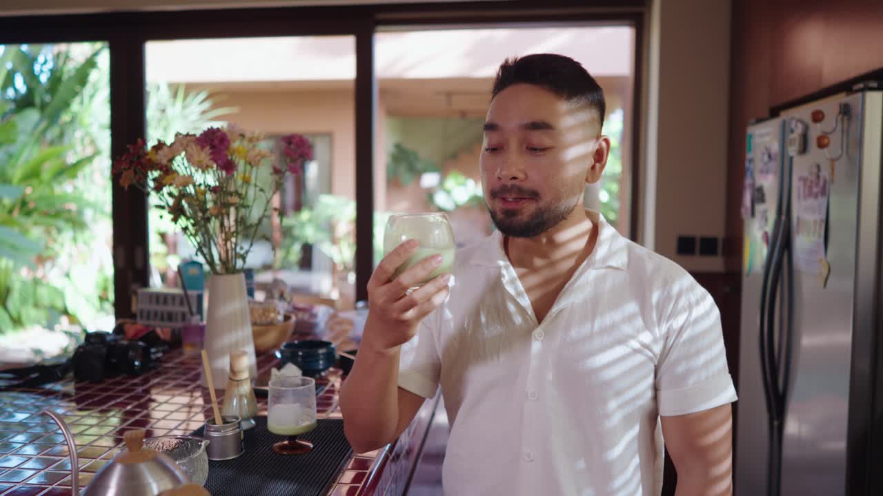 Man enjoying a Matcha Latte in his Kitchen