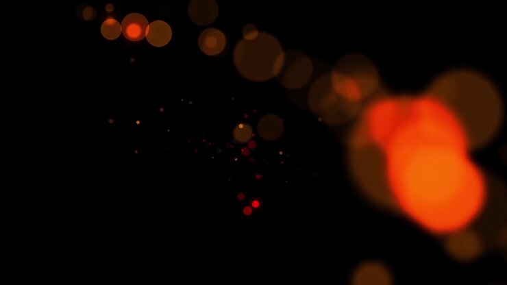 金の粒子が背景を動かすフラッシュライトで速いエネルギーを飛ぶ波線下から粒子黒い背景で点滅する金の粒子の塵