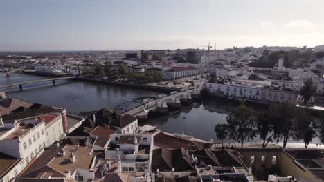 aerial orbiting view of famous tavira old bridge, roman bridge over gilao river, algarve