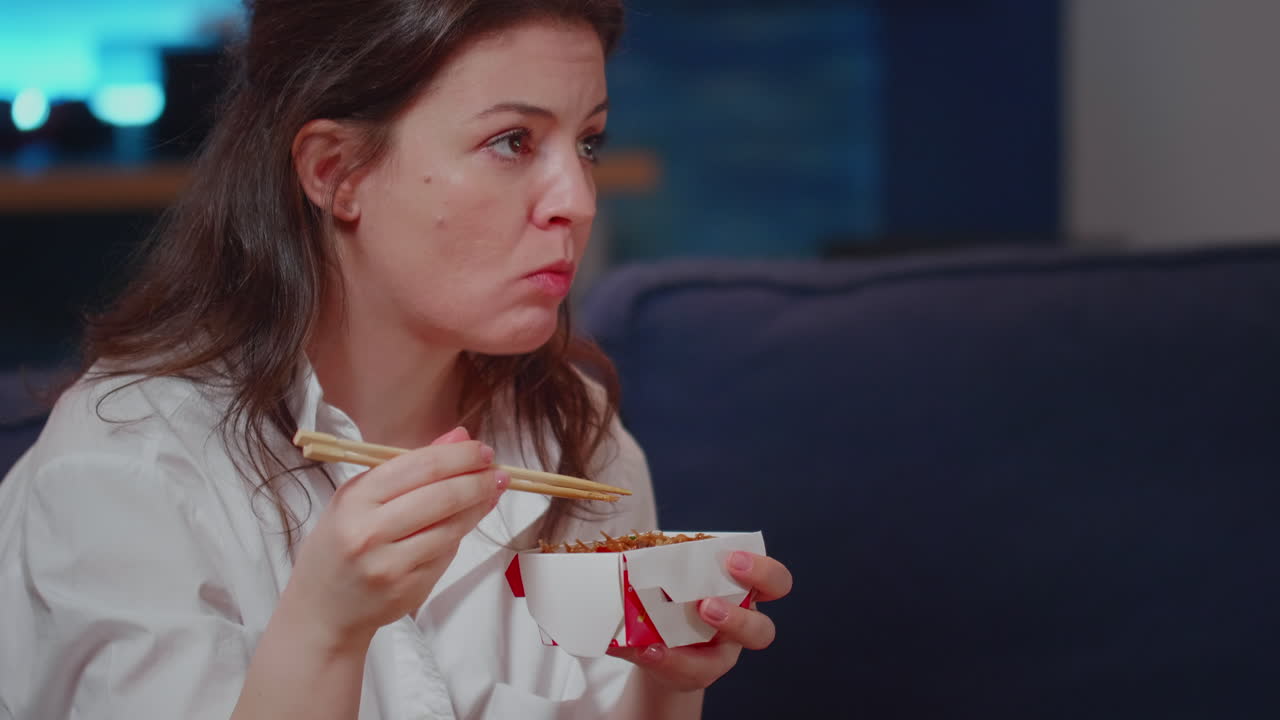 Close up of young woman using chopsticks for takeaway